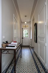 Hall d'entrée. Carreaux de ciment d'origine conservés. murs en nuance de gris et beige clair. plafond blanc satin