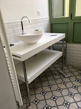 Meuble vasque dessiné et réalisé sur mesure par notre menuisier. Plan et tablette en corian avec porte serviette intégré. Pieds inox poli, vasque en béton blanchi