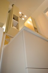 Meuble vasque de la salle de bains beige craie et colonnes de rangement autour du miroir jaune Renoir