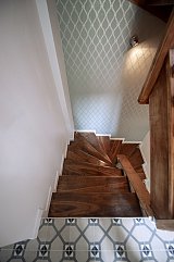 Escalier vers le RDC. Papier peint Farrow and Ball Criveli Trellis et carreaux de ciment au sol