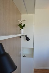 Détail de la tête de lit. Niche table de nuit, applique et tablette. Rail led encastré dans la sous face du placard haut